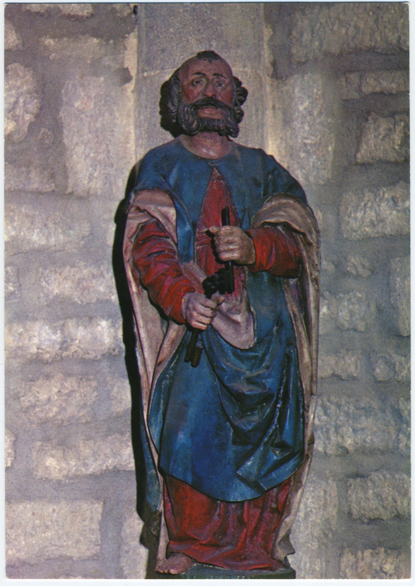 Photographie en couleur d'une statue en bois polychrome de Saint Pierre du XVIe siècle dans l'église de Landresse. Le saint porte une robe rouge, un manteau bleu et tient deux clés noires dans ses mains.